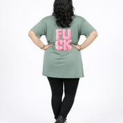 Person wearing a green t-shirt with 'FU**K' printed in pink on the back against a white background