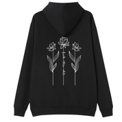 A black pullover hoodie with a white graphic print on the chest featuring a skull, stars, and the text 'DOG HAIR IS MY GLITTER'.
