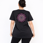 Woman wearing black oversized graphic tee with large intricate pink and teal mandala back print, plus size Australian streetwear by Bae Bands