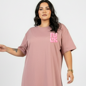 Person wearing a pink t-shirt with a graphic design on a plain background