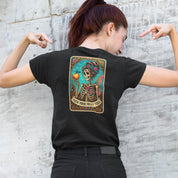 Person wearing a black t-shirt with a colorful graphic on the back against a concrete wall.