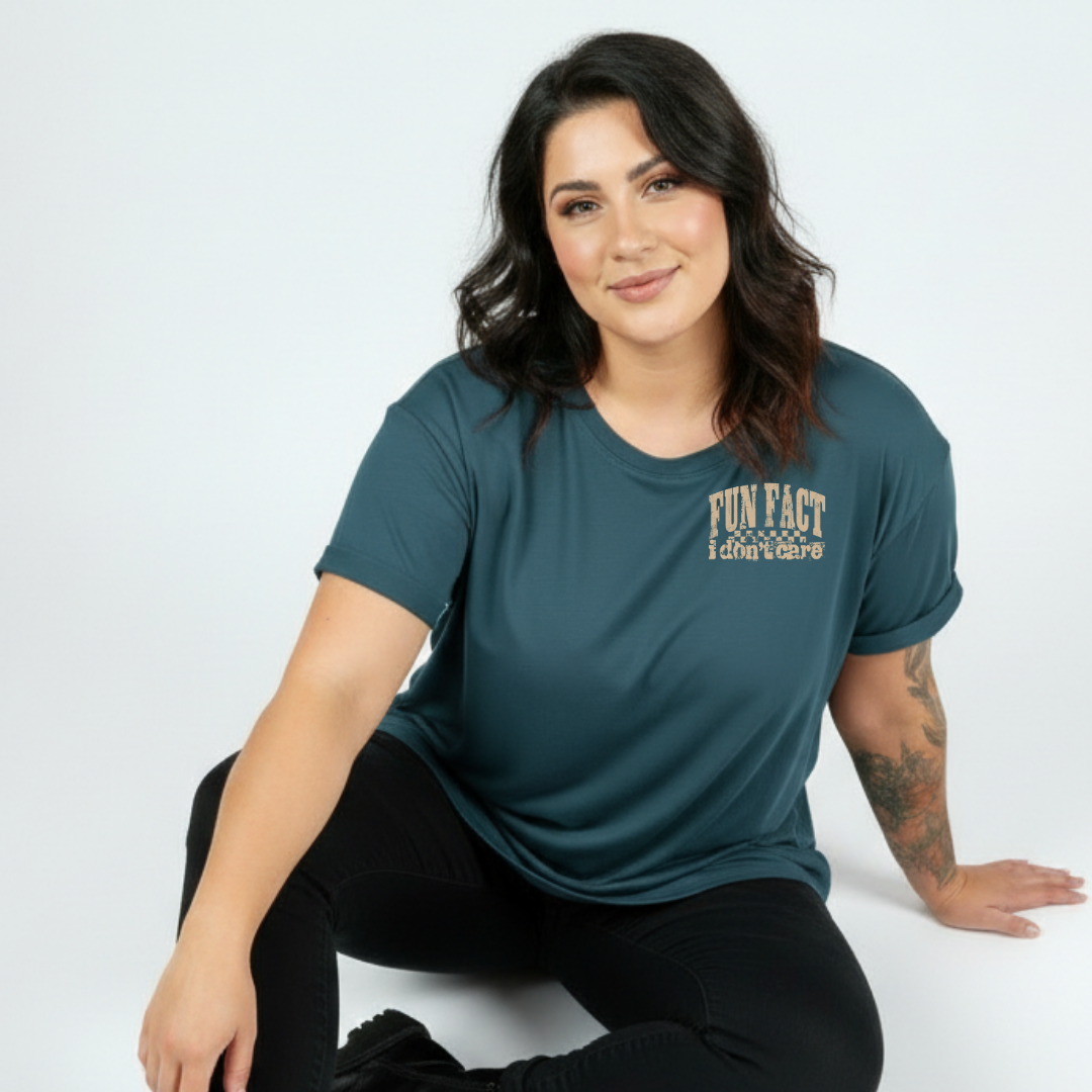 Woman wearing teal oversized graphic tee with Fun Fact I Don't Care distressed varsity slogan print, plus size Australian made streetwear by Bae Bands