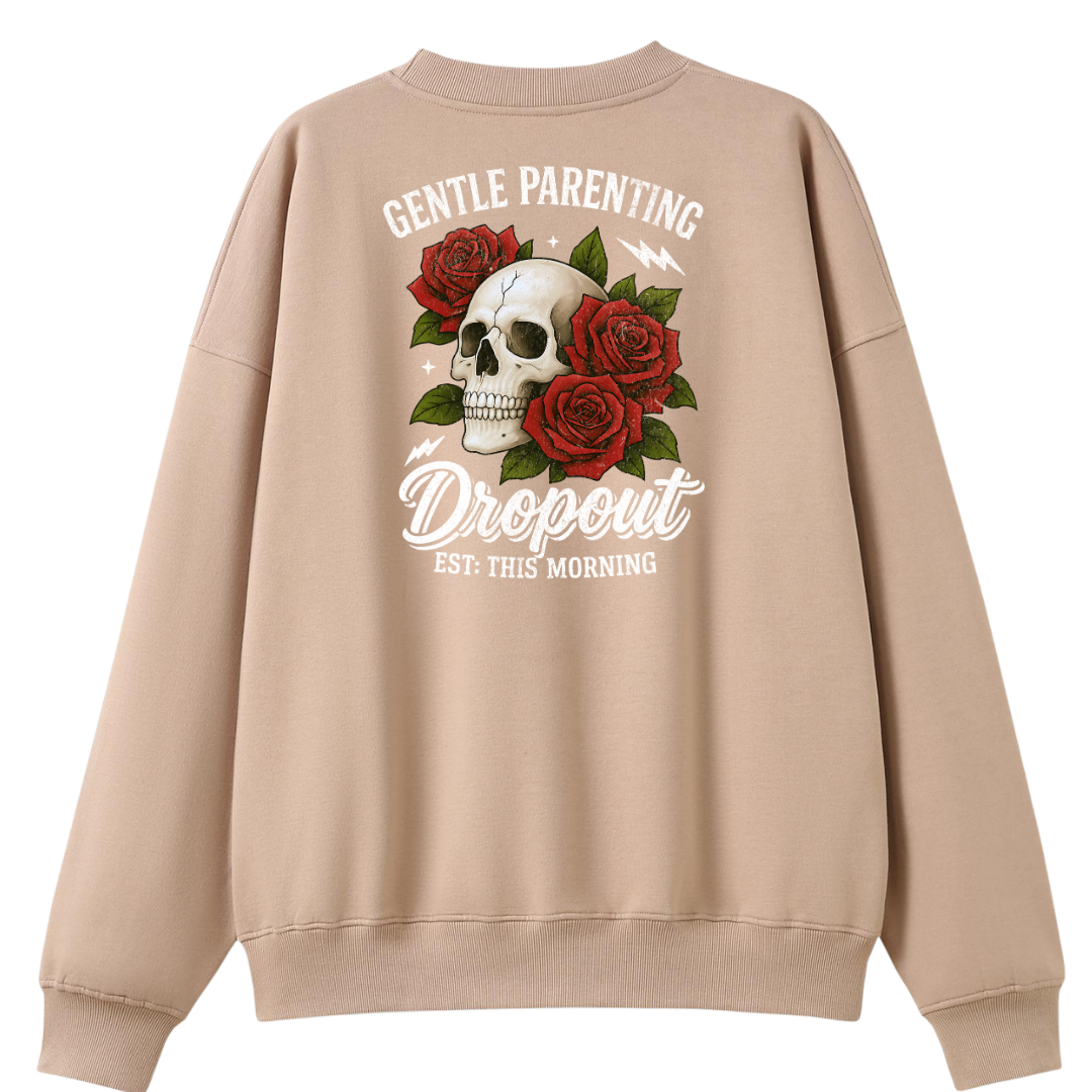 A beige crewneck sweatshirt shown from the back, featuring a graphic print of a white skull surrounded by red roses and the text 'GENTLE PARENTING Dropout EST. THIS MORNING'.