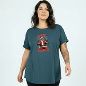 Woman wearing a teal t-shirt with a graphic design on a light blue background