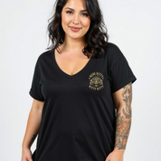 A woman wearing a black short-sleeve V-neck t-shirt with a gold 'HIDE KITTY KITTY' graphic on the left chest, set against a plain light gray background.