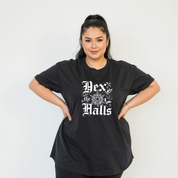 Person wearing a black t-shirt with 'Hex the Halls' text on a plain background