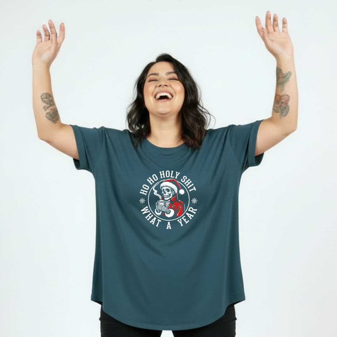 Person wearing a teal t-shirt with a graphic design and text, arms raised on a white background