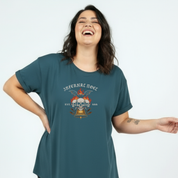 Woman wearing a teal t-shirt with a graphic design on a light blue background