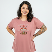 Woman wearing a pink t-shirt with a graphic design on a white background