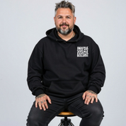 Front view of a man wearing black Inhale Good Shit Exhale Bullshit hoodie, relaxed fit, bold wavy white typography, plus size Australian streetwear by Bae Bands