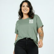 Woman wearing slate green oversized graphic tee with Inhale Good Shit Exhale Bullshit bold stacked text print, plus size Australian streetwear by Bae Bands