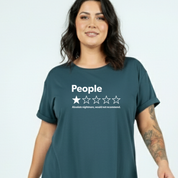 A woman wearing a dark teal graphic t-shirt with a white rating design that reads 'People' and 'Absolute nightmare, would not recommend.' against a light gray background.