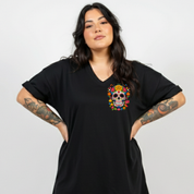 Woman wearing a black t-shirt with a colorful skull design on a plain background