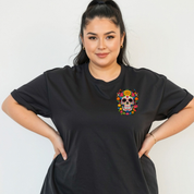 Woman wearing a black t-shirt with a colorful skull design on a plain background