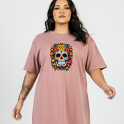 Woman wearing a pink t-shirt with a colorful skull design on a plain background