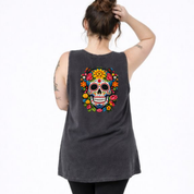 Person wearing a black sleeveless shirt with a colorful skull design on the back.