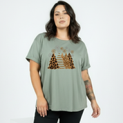 Woman wearing a green t-shirt with a leopard print design on a white background