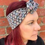 Woman wearing a floral headband against a brick wall