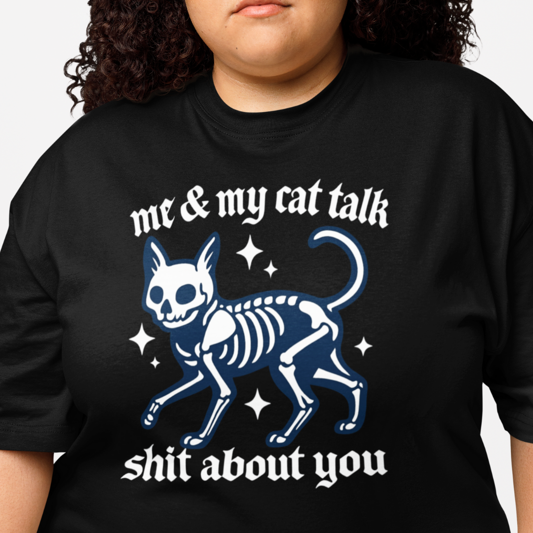 Black t-shirt with a cat skeleton graphic and text worn by a person