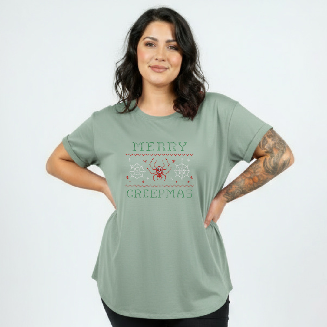 Woman wearing a green t-shirt with 'Merry Creepmas' text and design on a plain background