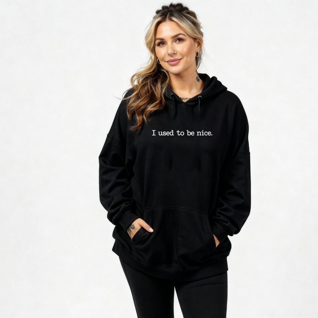 Woman wearing a black hoodie with 'I used to be nice.' text on a white background