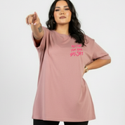 Woman wearing a pink t-shirt with text on a white background