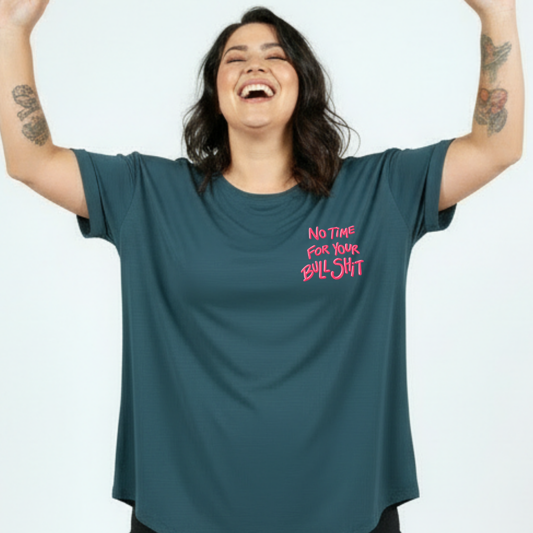 Person wearing a teal t-shirt with pink text on a white background