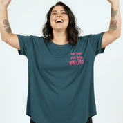 Person wearing a teal t-shirt with pink text on a white background