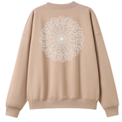 A beige crewneck sweatshirt shown from the back, featuring a large white circular mandala-style graphic printed across the upper back.