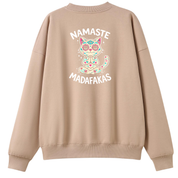 A beige crewneck sweatshirt shown from the back, featuring a colorful graphic of a meditating cat with 'NAMASTE MADAFAKAS' text in white.