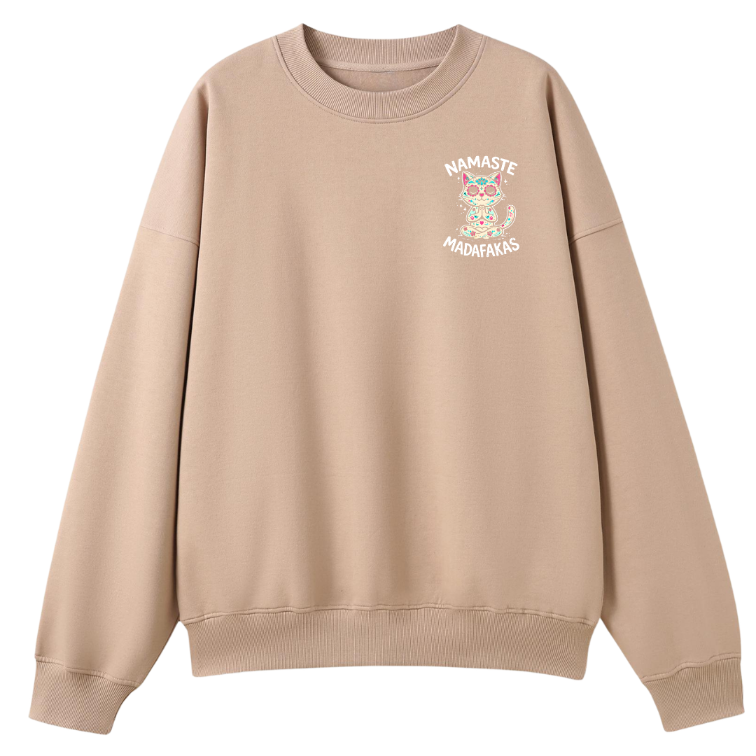 A beige crewneck sweatshirt with a small graphic on the left chest featuring a colorful owl and the text 'NAMASTE MADENAS'.