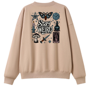A beige crewneck sweatshirt shown from the back, featuring a detailed graphic print with occult and fantasy illustrations including a moth, dagger, mushroom, tarot card, and the words 'Stay Weird'.