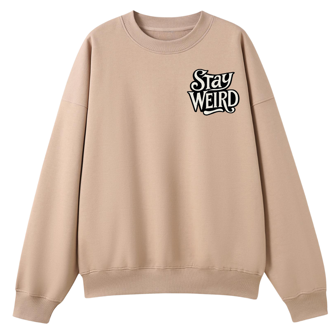 A beige crewneck sweatshirt with a black and white graphic text print reading 'Stay WEIRD' on the left chest, displayed on a solid white background.