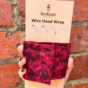 Red wire head wrap with packaging labeled 'Bae Bands Australia' against a red brick wall.