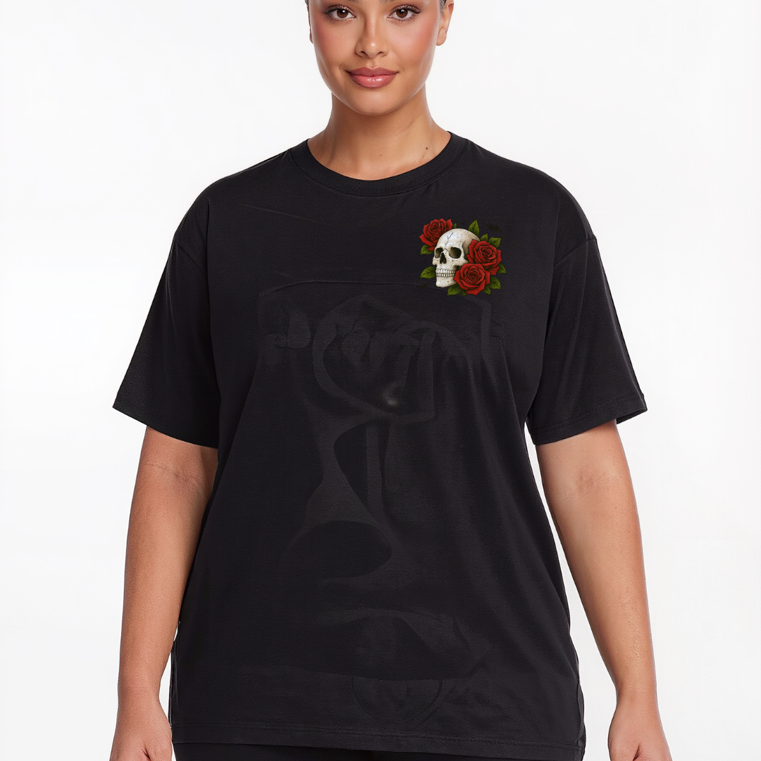 A woman wearing a black short-sleeve graphic t-shirt with a skull and red roses on the left chest, set against a plain white background.