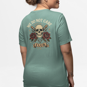 Slate Green plus-size tee with back print featuring “We Do Not Care Club,” skull emblem, barbed-wire, crossed bats and rose accents – Bae Streetwear