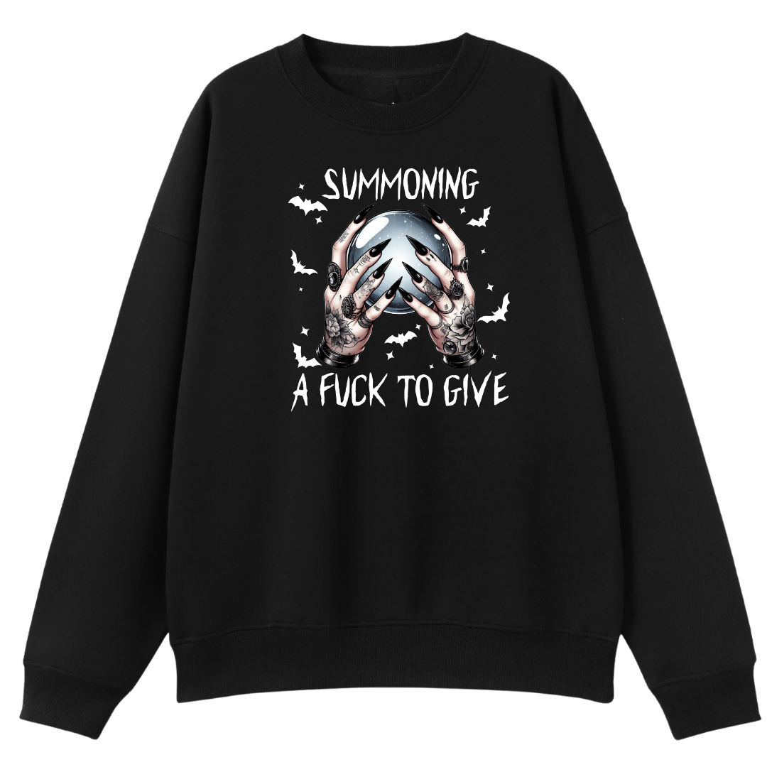 A black crewneck sweatshirt featuring a graphic print of tattooed hands holding a skull, surrounded by bats and the text 'SUMMONING A FUCK TO GIVE' in white and gray.