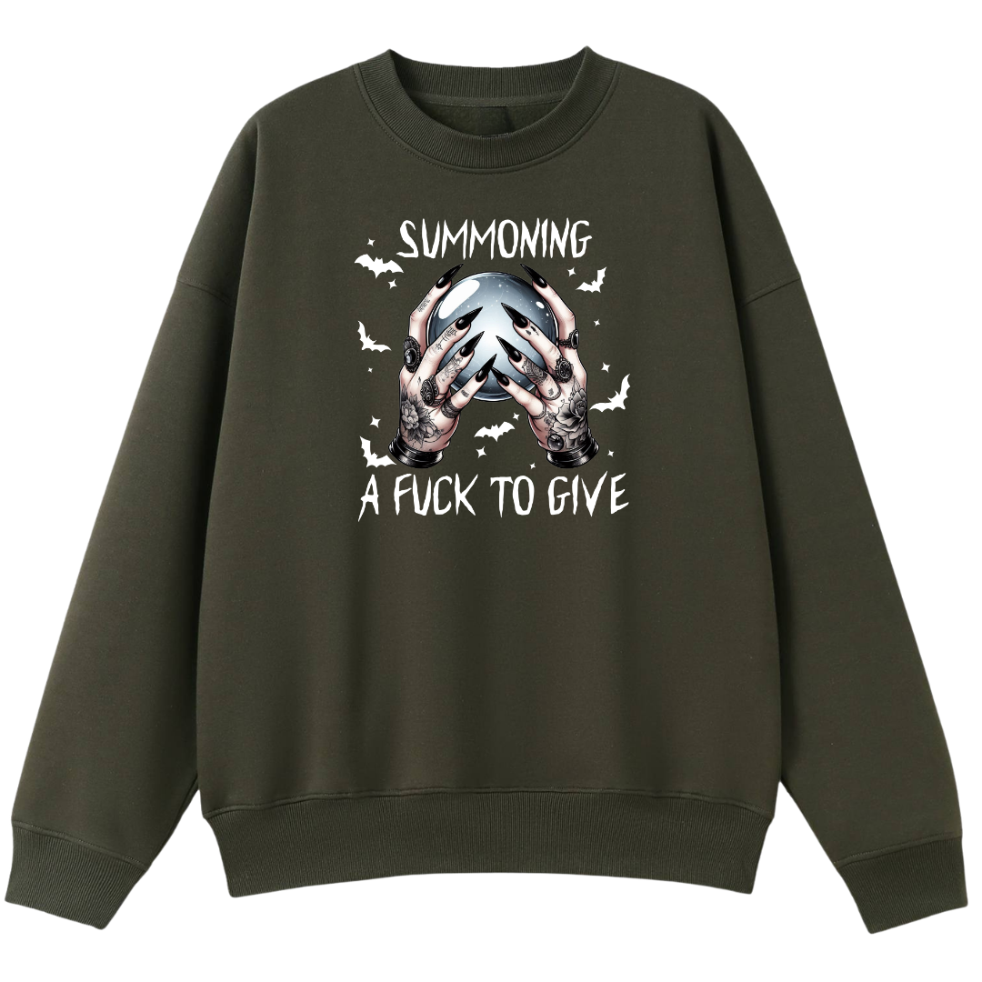 An olive green crewneck sweatshirt with a graphic print on the front showing hands holding a skull, surrounded by bats and the text 'SUMMONING A FUCK TO GIVE'.