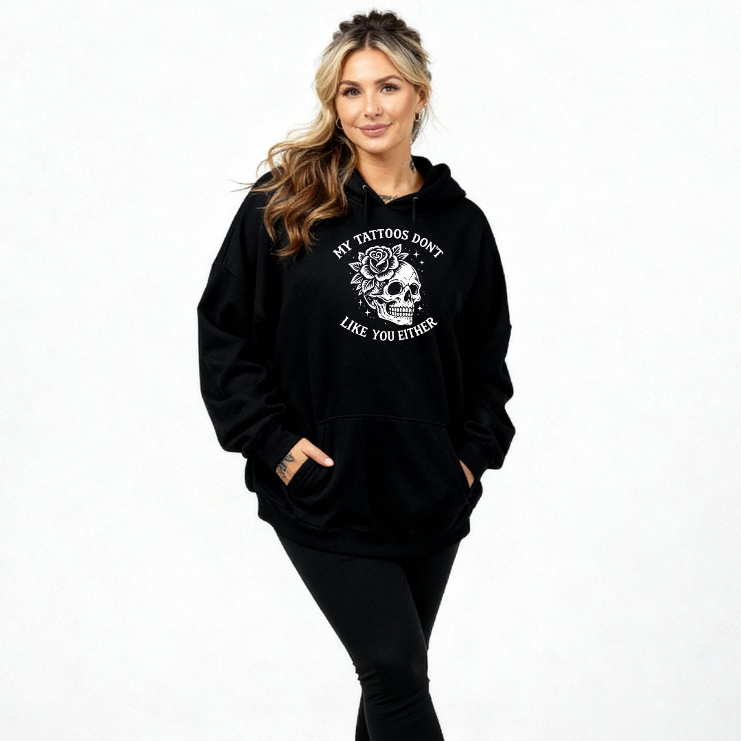 Woman wearing black oversized graphic hoodie with My Tattoos Don't Like You Either skull and rose back print, plus size Australian streetwear by Bae Bands