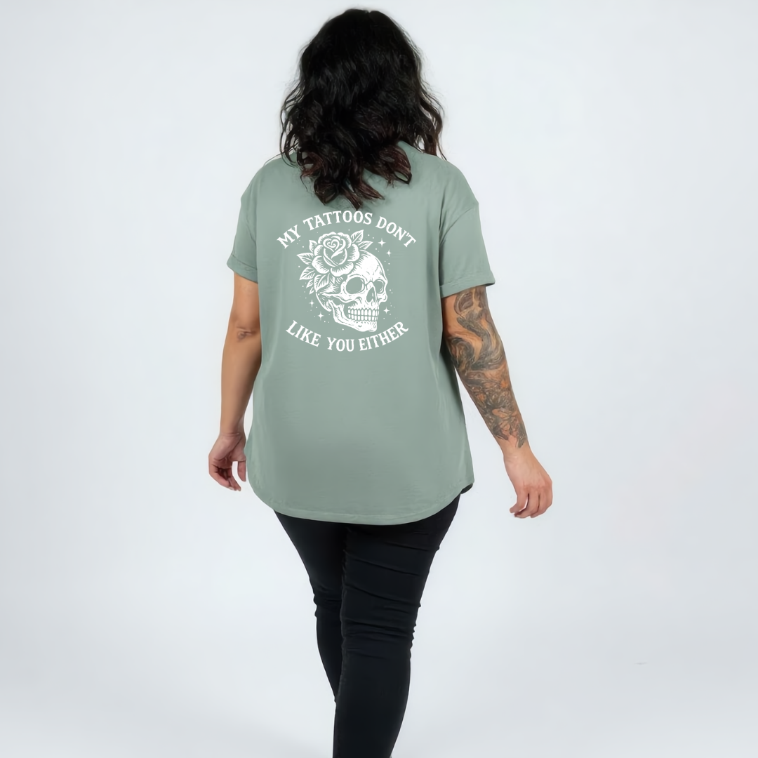 Woman wearing teal oversized graphic tee with My Tattoos Don't Like You Either skull and rose back print, plus size Australian made streetwear by Bae Bands
