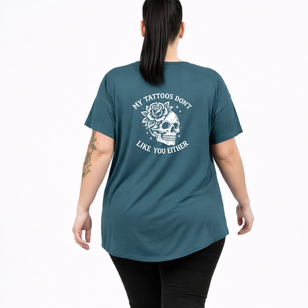 Woman wearing slate green oversized graphic tee with My Tattoos Don't Like You Either skull and rose back print, plus size Australian streetwear by Bae Bands