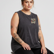 Woman wearing a black sleeveless shirt with a graphic design on a plain background