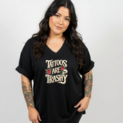 Woman wearing a black t-shirt with 'Tattoos Are Trashy' text and graphics.
