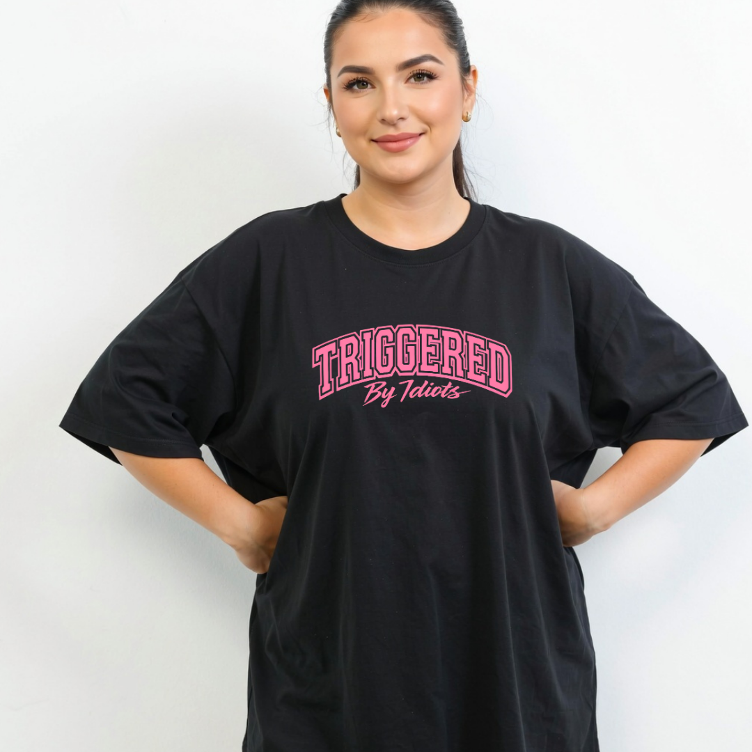 Person wearing a black t-shirt with pink text against a white background