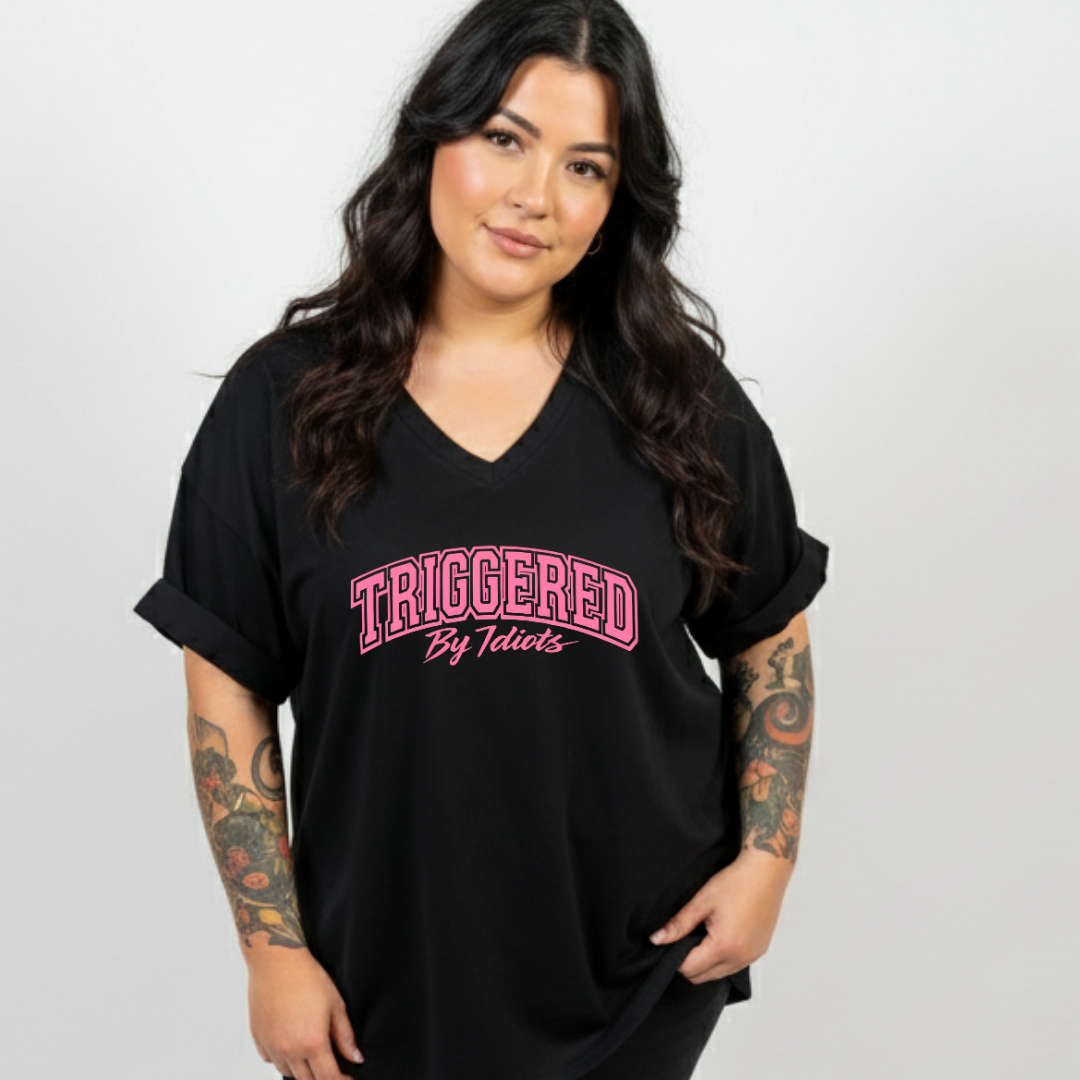 Woman wearing a black t-shirt with pink text on a plain background