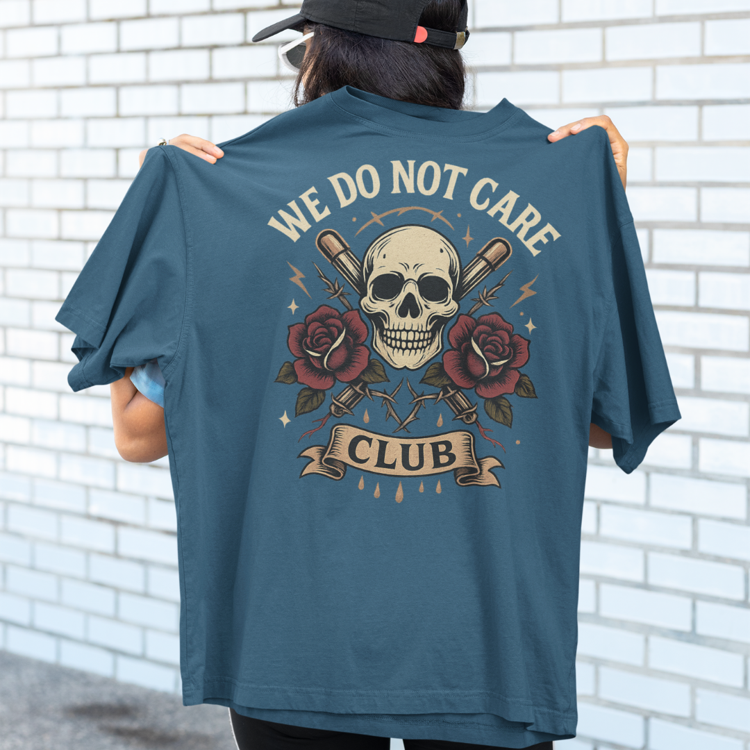 Plus-size graphic streetwear tee in Teal featuring “We Do Not Care Club” slogan above a skull, crossed bats and roses – handmade in Melbourne