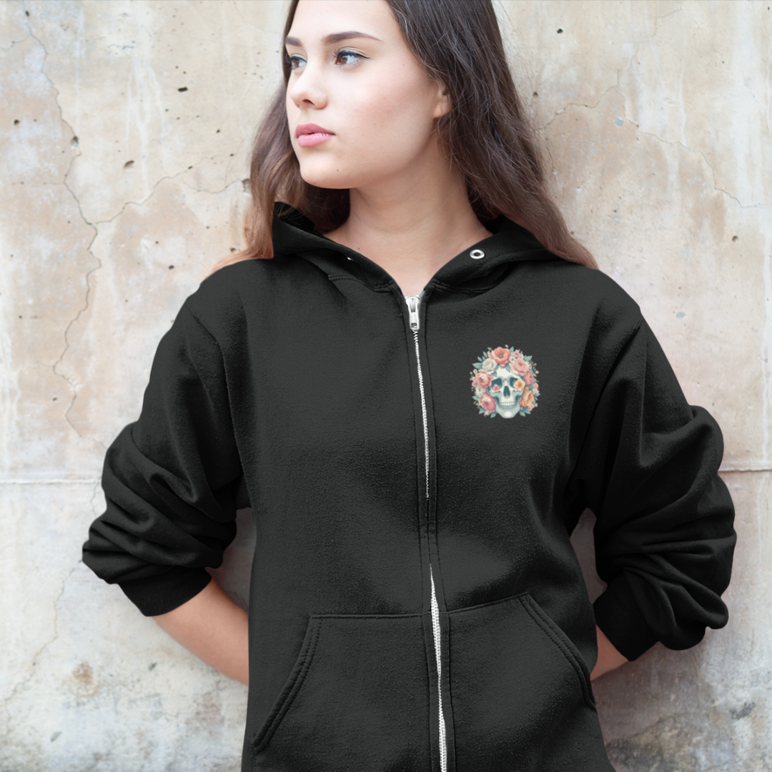 Person wearing a black hoodie with a colorful emblem on a textured wall background