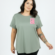 Woman wearing a green t-shirt with pink text on a plain background