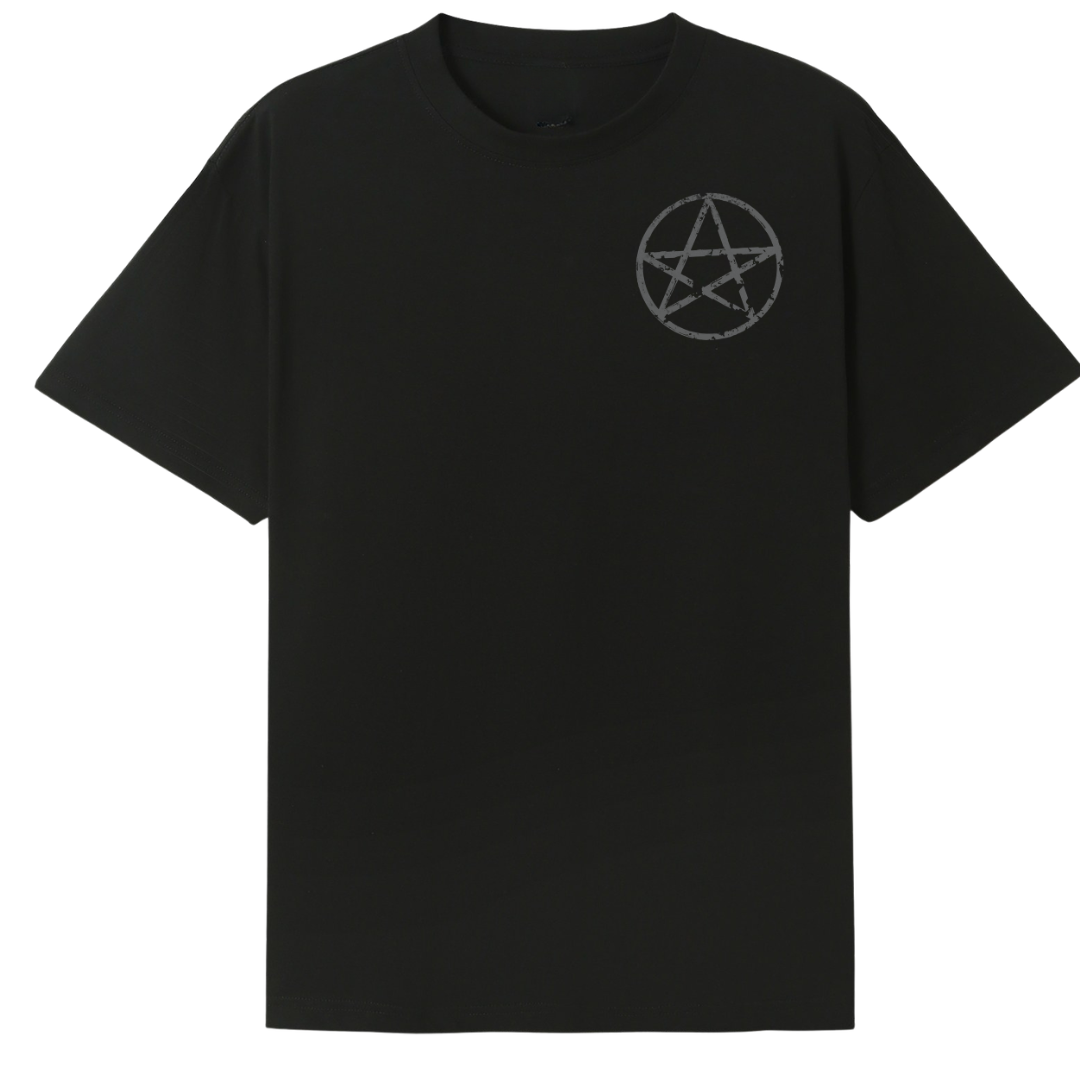 A black oversized tee with a small Village Witch graphic on the left chest.