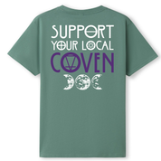 A slate green oversized tee shown from the back, with the Support Your Local Coven graphic printed large across the back, purple lettering above a triple moon.